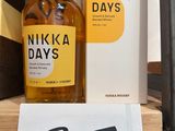 a bottle of nikka days on a shelf next to a book