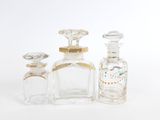 trois bouteilles en verre transparent ornées de bordures dorées et d'un bouchon doré