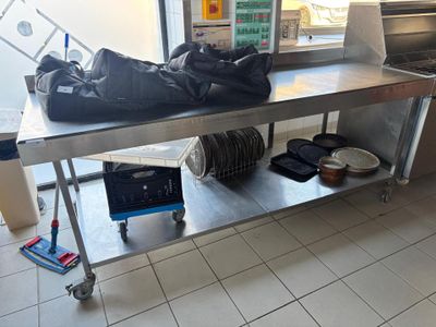 Une table de préparation roulante inox double plateaux avec dosseret