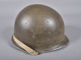 an old helmet is sitting on a white surface with a brown band around it