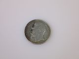 l'image d'une pièce de monnaie posée sur une surface blanche, sur fond blanc