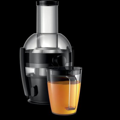 un verre de jus d'orange à côté d'un presse-agrumes sur fond noir