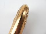 a close up of a gold plated object on a white surface