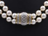a pearl and gold necklace with a snake clasp