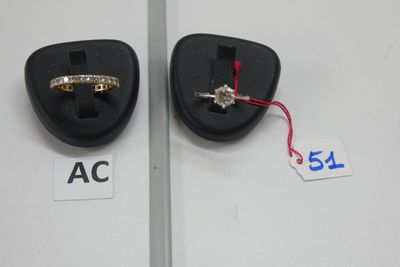 une paire de bagues de fiançailles en or et diamants exposées dans une vitrine