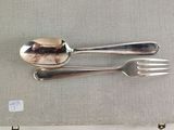 two silver spoons and a fork on a table