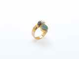 a gold ring with two oplites and a pearl