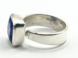 silver ring with a blue stone in it on a white surface