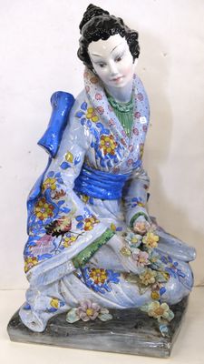 a figurine of a woman sitting on a table