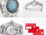 two watches and a red card are on a white surface