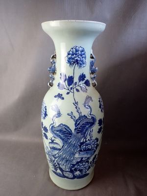 un vase bleu et blanc orné d'un oiseau et de fleurs