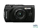 the black digital camera is sitting on a white surface