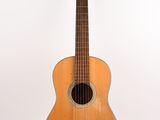 une image représentant une petite guitare posée sur une surface blanche