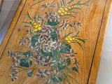 a wooden box with a painting on it next to a box with flowers