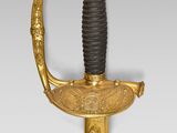 a gold plated sword with a black handle and a black handle