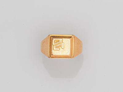 une chevalière en or sur laquelle est gravée la lettre « s »