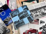 une pile de vieilles brochures automobiles posée sur une table