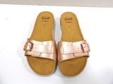 pink leather sandals with buckles on a white surface