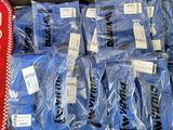 de nombreux sacs contenant des chemises bleues et une écharpe rouge exposés