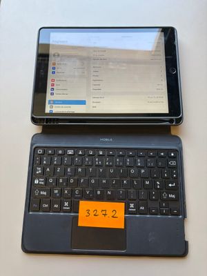 a tablet computer sitting on top of a laptop keyboard