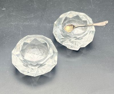 two clear glass bowls with spoons on a table