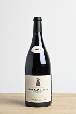 the bottle of wine is sitting on a wooden table