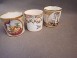 three cups with a picture of a woman and a basket of fruit on them