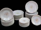 a lot of white plates with gold designs on them
