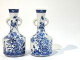paire de vases bleus et blancs posés sur une surface blanche