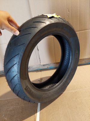 someone is holding a tire that is on the ground in front of a wall