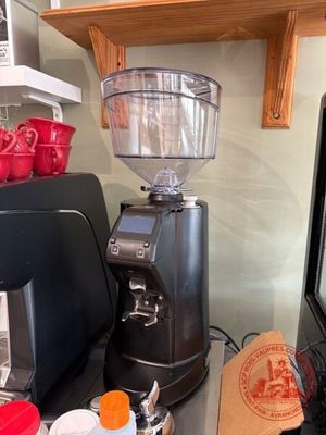 un moulin à café posé sur un plan de travail, à côté d'un micro-ondes
