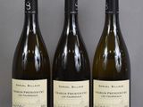 three bottles of wine are lined up on a table