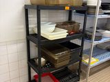 une étagère noire sur laquelle sont posés des plats, dans une cuisine