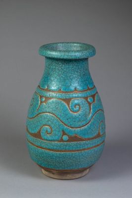 a blue vase with gold designs on it on a gray surface