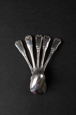 a silver spoon and spoon rest on a black surface