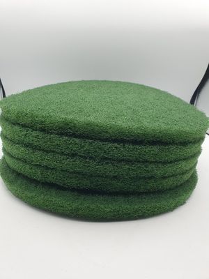 quatre éponges vertes empilées les unes sur les autres sur une surface blanche