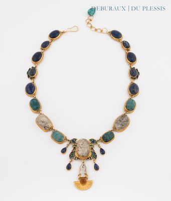 a gold necklace with blue and green stones on it