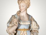 statue of a woman in a blue dress holding a flower