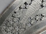 a close up of a silver plate with a fish on it