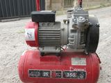 a red air compressor sitting on the ground