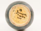 a blue vase with writing on it sitting on a white surface