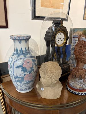 trois vases posés sur une table sur laquelle se trouve une horloge