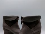 La femme porte une paire de bottes marron à talons noirs.