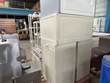 a stack of white cabinets in a warehouse with blue bins