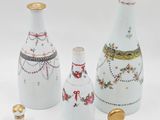 three white vases with different designs on them