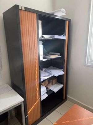 a black cabinet with a wooden door in the corner of a room