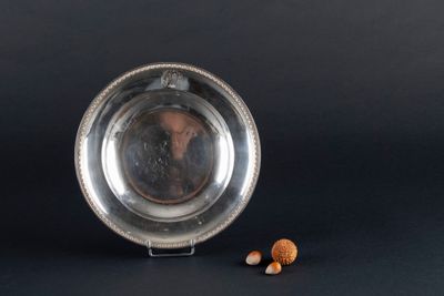 a silver plate with nuts in it on a black background
