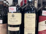plusieurs bouteilles de vin rouge sont alignées sur un comptoir