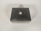 a small square metal object on a white surface