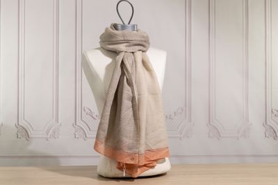 the scarf is hanging on a mannequin in front of a white wall